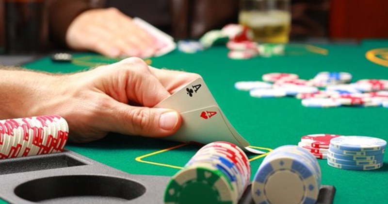 Gần cận về các con chip poker và lá bài trên bàn xanh